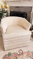 Front view of cream barrel chair showing overall style and skirted base
