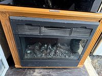 Front view of Heat Surge electric fireplace with oak mantle and black heater insert