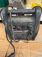 Front view of portable jump starter showing handle, LED indicators, 12V socket and charge port