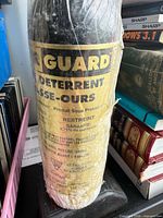 Bear spray canister wrapped in plastic on small electronic device