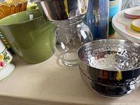 Group showing green bowl, glass candle bowl, hammered stainless bowls