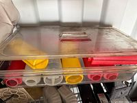 Clear plastic tray with lid containing multiple squeeze condiment bottles
