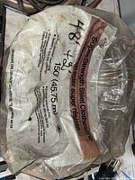 plastic sleeve labeled super-strength steel clothesline 150 ft showing coil inside