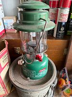 Overall view of green Coleman Easi-Lite lantern sitting on base