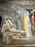 Bag of off-white curtain rod brackets and mounting plates