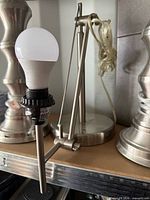 Full view of brushed metal adjustable lamp with LED bulb installed