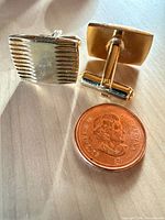 Front view of both cufflinks beside coin for scale