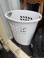 White plastic perforated laundry hamper with handles