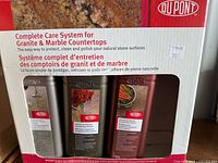 Front of boxed DuPont Complete Care System showing three bottles for granite & marble countertop maintenance