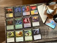Fifteen assorted Magic: The Gathering cards laid out on a table, several in foil