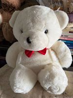 front view of white teddy bear with red bow