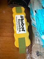 Yellow iRobot Roomba Advanced Power System battery pack on shelf