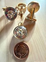 Front view of two roulette cufflinks, keychain and reference coin