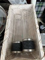Two glass mills inside woven basket