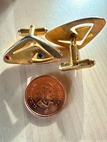 Front and back of both cufflinks beside coin
