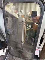 Front of tinted glass sunroof showing gasket and hinges