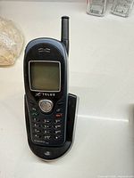 Front view of Telus digital cell phone placed in charging cradle