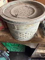 Side view of galvanized perforated tub with lid showing overall form and condition