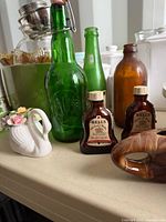 Overall shot showing multiple bottles, swan creamer and background objects