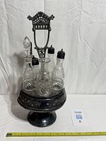 Full view of silverplate stand with five etched glass bottles in place