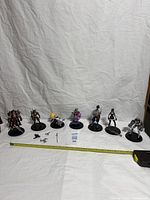 All seven League of Legends figures lined up with accessories and tape measure