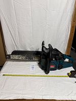 Full view of Makita chainsaw with measuring tape showing bar length