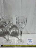 Both crystal goblets standing side by side with measuring tape for scale