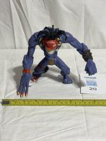 Front angled view of Insaniac action figure beside ruler showing size