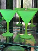 Four uranium glass martini glasses in display cabinet