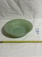 Top view of jadeite green swirl bowl with measuring tape showing diameter