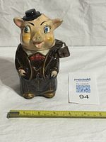 Front view of piggy bank showing attire and facial details