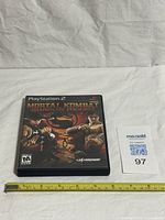 Front view of PS2 game case with ruler for scale
