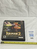 Front view of PlayStation 2 Rayman 2 Revolution case with measuring tape for scale and lot tag
