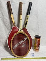 Three rackets standing with covers and Wilson ball can for overall view