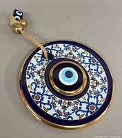 Front view of round evil eye wall hanging charm with floral pattern and central eye medallion