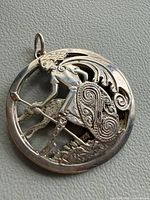 Front view of brooch showing warrior, shield, wolfhound and bail