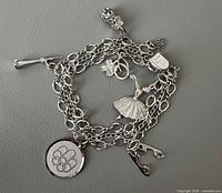 Coiled sterling silver charm bracelet showing attached charms