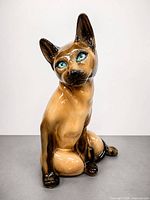 Front three-quarter view of glossy porcelain Siamese cat figurine