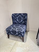 Front view of upholstered slipper chair showing fabric pattern and wooden legs