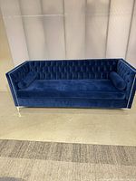 Full front view of blue velvet tufted sofa