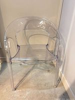 Front view of clear acrylic chair showing seat and curved backrest