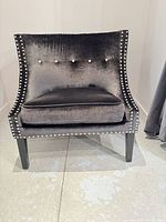 Front view showing velvet upholstery, nailhead trim, cushion