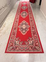 Full view of red oriental runner rug in hallway