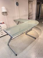 Assembled L-shaped frosted glass desk showing overall structure and metal legs