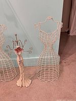 Overall shot of two wire dress forms and ceramic/resin stand