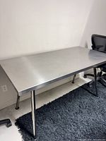 Full view of stainless steel table with chrome legs