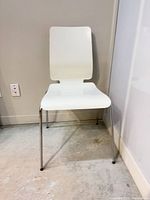 Front view of white stacking chair showing full form