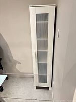 Full view of tall white cabinet against wall