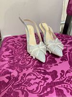 Top view of both shoes showing glitter finish, bow embellishment, slingback style