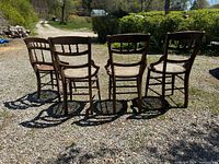 Four mahogany chairs rear view showing backrest design and cane seats